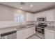 Bright kitchen with white cabinets, granite countertops, stainless steel appliances, and tile flooring at 12801 W Sweetwater Ave, El Mirage, AZ 85335