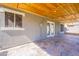 Covered patio boasting stone flooring, a wooden ceiling, and access to the home's interior at 12801 W Sweetwater Ave, El Mirage, AZ 85335