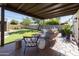 Spacious backyard with a covered patio, lush green lawn, mature trees, and comfortable outdoor seating at 1309 W Lynwood St, Phoenix, AZ 85007