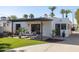 Beautiful backyard featuring a covered patio, dining area, cozy seating, lush green lawn, and mature trees at 1309 W Lynwood St, Phoenix, AZ 85007