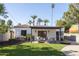 Lush backyard features a covered patio, outdoor seating, dining area, mature trees, and beautiful landscaping at 1309 W Lynwood St, Phoenix, AZ 85007