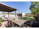 Charming backyard featuring a covered patio, dining table, and expansive lawn, ideal for outdoor gatherings at 1309 W Lynwood St, Phoenix, AZ 85007