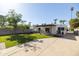 Expansive backyard with a covered patio, dining area, mature trees, and lush green lawn, perfect for outdoor enjoyment at 1309 W Lynwood St, Phoenix, AZ 85007