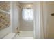 Bright bathroom featuring a shower-tub combination with white tile, modern fixtures, and neutral decor at 1309 W Lynwood St, Phoenix, AZ 85007