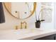 Bathroom vanity featuring a round mirror, gold faucet, and white countertop, complemented by stylish decor at 1309 W Lynwood St, Phoenix, AZ 85007