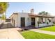 A charming single-story home featuring a red tile roof, a well-manicured lawn, and a secure gated driveway at 1309 W Lynwood St, Phoenix, AZ 85007