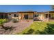 Inviting backyard with covered patio, rock landscaping, and lush green grass at 131 N Higley Rd # 41, Mesa, AZ 85205