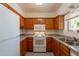 Bright kitchen boasts granite countertops, white appliances, and wooden cabinets at 131 N Higley Rd # 41, Mesa, AZ 85205