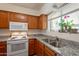 Kitchen with granite counters, a view of the garden from the window, and wooden cabinets at 131 N Higley Rd # 41, Mesa, AZ 85205