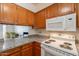 Kitchen with granite countertops, white appliances, and wooden cabinets at 131 N Higley Rd # 41, Mesa, AZ 85205