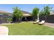 Private backyard with artificial turf, fireplace, and lounge chairs at 15562 W Cameron Dr, Surprise, AZ 85379
