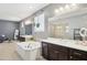 Primary bath with dual vanities, soaking tub, modern fixtures and ample counter space at 15562 W Cameron Dr, Surprise, AZ 85379