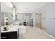 Well lit primary bathroom featuring a soaking tub, walk-in shower, and dual sink vanity at 15562 W Cameron Dr, Surprise, AZ 85379