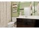 Charming bathroom with a decorative mirror, green walls, and a modern vanity at 15562 W Cameron Dr, Surprise, AZ 85379