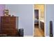 Open doorway leading to a bedroom with a chest of drawers and a bathroom beyond at 15562 W Cameron Dr, Surprise, AZ 85379