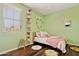 Bright bedroom with floral decor, wood floors, and a cozy daybed with plush pillows at 15562 W Cameron Dr, Surprise, AZ 85379