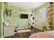 Stylish bedroom with leafy decor, wood floors, and a modern desk at 15562 W Cameron Dr, Surprise, AZ 85379
