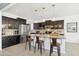 Modern kitchen with granite countertops, stainless steel appliances, and bar stool seating at 15562 W Cameron Dr, Surprise, AZ 85379