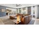 Open-concept living room with brown leather furniture, neutral tones, and plenty of natural light at 15562 W Cameron Dr, Surprise, AZ 85379