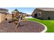 Spacious backyard with a play structure, patio area, and artificial turf for Gathering fun at 15740 W Washington St, Goodyear, AZ 85338