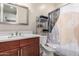 Well-lit bathroom with vanity, mirror, toilet, and shower with decorative curtain at 15740 W Washington St, Goodyear, AZ 85338