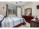 Comfortable bedroom features a ceiling fan, natural light, and traditional furnishings at 15740 W Washington St, Goodyear, AZ 85338