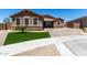 Charming single-story home with stone accents, green lawn, and a brick driveway at 15740 W Washington St, Goodyear, AZ 85338