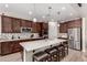 Spacious kitchen with dark wood cabinets and large island with seating at 15740 W Washington St, Goodyear, AZ 85338
