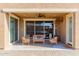 Comfortable covered patio featuring cushioned seating, ceiling fan, and sliding glass doors to the home's interior at 15740 W Washington St, Goodyear, AZ 85338