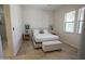Well-lit bedroom with a neutral color palette, tile flooring, and window with bright light at 16386 W Papago St, Goodyear, AZ 85338