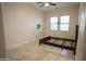 The vacant bedroom offers tile flooring, neutral walls and a modern ceiling fan at 16386 W Papago St, Goodyear, AZ 85338