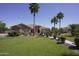 Inviting home with lush green lawn, mature palm trees, and a stone-detailed front entrance at 16386 W Papago St, Goodyear, AZ 85338