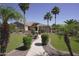 Charming single-story home featuring a manicured lawn, lush landscaping, and a stone-accented entrance at 16386 W Papago St, Goodyear, AZ 85338