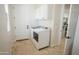 Laundry room with white washer and dryer and tile floors at 16386 W Papago St, Goodyear, AZ 85338
