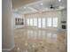 Bright, open living room features a stone fireplace, ceiling fan, and multiple windows for ample natural light at 16386 W Papago St, Goodyear, AZ 85338