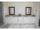 Bright bathroom with double sinks, granite counters, and white cabinetry at 16386 W Papago St, Goodyear, AZ 85338