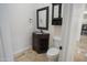 Charming powder room with dark wood vanity and decorative mirror at 16386 W Papago St, Goodyear, AZ 85338