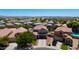 Expansive aerial view of a suburban home featuring a pool, lush landscaping, and a tile roof at 19324 N Del Mar Ave, Maricopa, AZ 85138