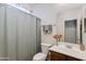 Bright bathroom featuring a single sink vanity, framed mirror, and a shower with a curtain at 19324 N Del Mar Ave, Maricopa, AZ 85138