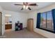 Well-lit bedroom with a window seat, ceiling fan, and adjacent bathroom at 19324 N Del Mar Ave, Maricopa, AZ 85138