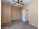 A simple, carpeted bedroom features a ceiling fan and a door at 19324 N Del Mar Ave, Maricopa, AZ 85138