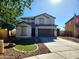 Two-story home featuring a two-car garage, neutral color scheme, manicured yard with artificial grass and rock details at 19324 N Del Mar Ave, Maricopa, AZ 85138