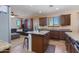 Open-concept kitchen with granite countertops, stainless steel appliances, tile floors and island seating at 19324 N Del Mar Ave, Maricopa, AZ 85138