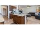 Kitchen island featuring granite countertops, storage, and seating in an open-concept layout at 19324 N Del Mar Ave, Maricopa, AZ 85138