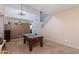 Open living area with a high ceiling, visible staircase, and a pool table ready for play at 19324 N Del Mar Ave, Maricopa, AZ 85138