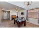 Spacious living room with a pool table, a ceiling fan, and bright natural light at 19324 N Del Mar Ave, Maricopa, AZ 85138
