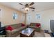 Comfortable living room with neutral colors, ceiling fan, and small windows at 19324 N Del Mar Ave, Maricopa, AZ 85138