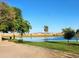 Scenic pond reflecting the sky and surrounded by lush trees and greenery in a community setting at 19324 N Del Mar Ave, Maricopa, AZ 85138