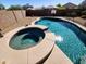 Backyard pool and spa featuring flagstone surround, steps and tile accents with views of the surrounding neighborhood at 19324 N Del Mar Ave, Maricopa, AZ 85138