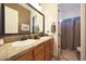 Well-lit bathroom features a double vanity with a view to the toilet and shower at 19334 W Pasadena Ave, Litchfield Park, AZ 85340